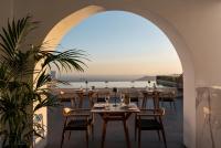 Un restaurante con mesas y sillas y vista al mar. en Aeifos Boutique Hotel, en Imerovigli