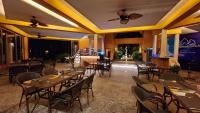 un ristorante con tavoli, sedie e soffitto di Blue Haven Bay Villa 21D and Resort Apartments a Ko Chang