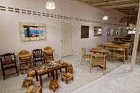 um restaurante com mesas e cadeiras de madeira e mesas e cadeiras em Blue Turtle Hotel Samui em Chaweng