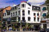Un edificio blanco con gente caminando frente a él. en Hotel The Century, en Hasselt