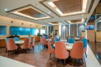 Un restaurante con mesas y sillas en una sala. en Bel-La Monde Hotel Chhattarpur South Delhi, en Sat Bari