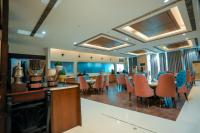 Un comedor con sillas naranjas y una mesa. en Bel-La Monde Hotel Chhattarpur South Delhi, en Sat Bari