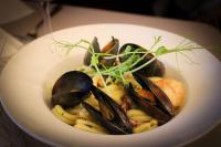 Un plato de comida con mejillones y camarones sobre pasta. en Pałac na Wodzie Hotel & SPA, en Jelenia Góra
