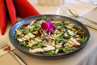 Una ensalada con queso y verduras en una sartén sobre una mesa. en Pałac na Wodzie Hotel & SPA, en Jelenia Góra