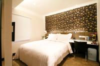 a bedroom with a white bed and a desk with a computer at Hotel Puri in Taipei