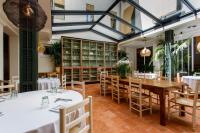 Un comedor con mesas y sillas blancas. en Hostal Spa Olga, en Sant Antoni de Calonge