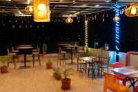 a patio with tables and chairs and lights at Majestic Hotel and Restro in Udaipur
