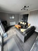 una sala de estar con un sofá y una mesa en Self Catering Spacious 2 Bed Apartment with sea views, en South Erradale