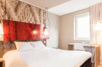 a bedroom with a white bed and a red wall at ibis Paris Bastille Faubourg St Antoine in Paris