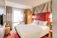 a hotel room with a large white bed and a tv at ibis Paris Bastille Faubourg St Antoine in Paris