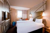 a hotel room with two beds and a tv at ibis Paris Bastille Faubourg St Antoine in Paris