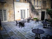 an outdoor patio with tables and chairs and a building at The Gainsborough Bath Spa - Small Luxury Hotels of the World in Bath