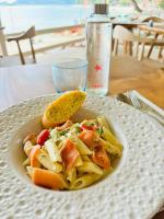 um prato de massa sobre a mesa com uma garrafa de água em Blue Turtle Hotel Samui em Chaweng