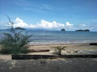 einen Sandstrand mit Inseln im Wasser in der Unterkunft Red Coral Cottage in Tanjung Rhu
