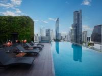una piscina con tumbonas y vistas al perfil urbano en Amara Bangkok Hotel, en Bangkok