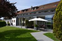 ein Gebäude mit Regenschirm und Rasen in der Unterkunft Auberge de Confignon in Genf