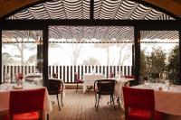 a restaurant with white tables and chairs and a large window at Secrets Mallorca Villamil Resort & Spa - Adults Only (+18) in Paguera