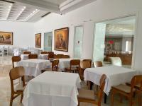 a dining room with white tables and chairs at Blumar Resort & Spa in Hammamet