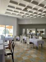 a dining room with white tables and white chairs at Blumar Resort & Spa in Hammamet
