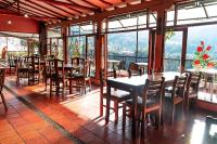 Un restaurante con mesas, sillas y ventanas. en Hospedaje La Casona de San Francisco, en Monguí