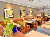 Holiday Inn Hotel & Suites Regina by IHG في ريجينا: غرفة طعام مع طاولات وكراسي خشبية