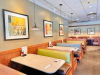 Holiday Inn Hotel & Suites Regina by IHG في ريجينا: مطعم يحتوي على عدة طاولات وكراسي في الغرفة