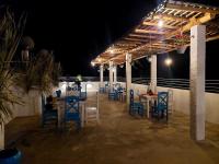 Een groep blauwe stoelen en tafels op een terras 's nachts. bij Kingcity Resort in Anuradhapura