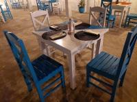 een witte tafel met twee blauwe stoelen en een tafel met borden en servetten bij Kingcity Resort in Anuradhapura