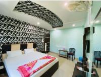 a bedroom with a bed and two chairs in a room at Basant Vihar International in Gaya