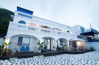 a white house with a patio in front of it at Shengtuolini B&amp;B in Yanliau