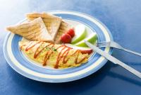 a plate of food with an omelet and crackers and fruit at Shengtuolini B&amp;B in Yanliau