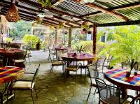 a patio with tables and chairs in a restaurant at Hotel y Restaurante Alicante de Montaña, El Salvador in Los Tablones