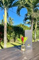 un vaso di fiori seduto su un tavolo con un libro di Sands of Rarotonga Hotel ad Avarua