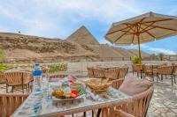 un tavolo con del cibo sopra e una piramide sullo sfondo di The Grand Pyramids View Hotel a Il Cairo