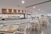 ein Restaurant mit Holztischen und Stühlen und einer Theke in der Unterkunft Alua Gran Camp de Mar in Camp de Mar