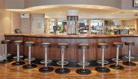 eine Bar mit einer Sitzreihe davor in der Unterkunft Lancaster Gate Hotel in London