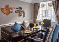 ein Wohnzimmer mit einer Couch und einem Tisch in der Unterkunft Lancaster Gate Hotel in London