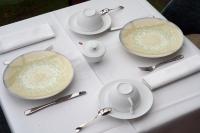 einem weißen Tisch mit Tellern, Tassen und Löffeln in der Unterkunft La Borie d'Hélipse in Tournemire