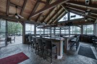 een restaurant met een bar met stoelen en ramen bij Lena's Northern Pines Resort in Park Falls