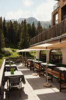 una fila de mesas y sombrillas en un patio en Hotel Boè Sport and Nature, en Arabba