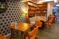 a restaurant with tables and chairs in a room at Ohtel Auckland in Auckland