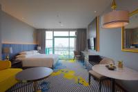 a hotel room with two beds and a couch and tables at Chatrium Hotel Riverside Bangkok in Bangkok