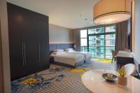 a hotel room with a bed and a table at Chatrium Hotel Riverside Bangkok in Bangkok