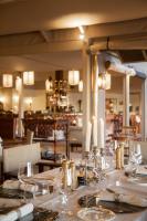 Gmundner Lodge في ويندهوك: غرفة طعام مع طاولة مع كؤوس للنبيذ