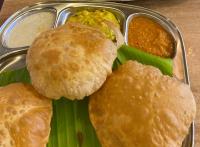 Un plato de comida con pan y otros alimentos. en AJ Gable Clouds Ooty by VOYE HOMES - Serene Stay Near Avalanche Emerald Lake, en Ooty