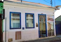 un antiguo edificio blanco con puertas y ventanas azules en Pousada Itatiba Conforto, en Itatiba