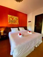 a bedroom with a large white bed with red walls at Hotel Pousada Marambaia in Arraial d'Ajuda
