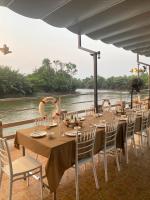 Una mesa preparada para una comida junto a un río en Dhammachart RiverView, en Samut Songkhram
