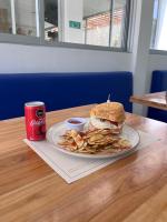 Un sándwich y patatas fritas en un plato con una lata de refresco. en Hotel Aqua House, en Tubará