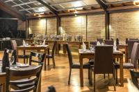 Un comedor con mesas y sillas de madera. en Manthila Hotel, en Anuradhapura